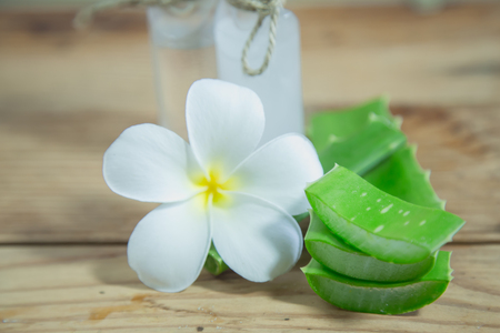 Aloe vera Fresh stacked with drop water and aloe vera juice in glass bowl with honey in jar on old woodの写真素材