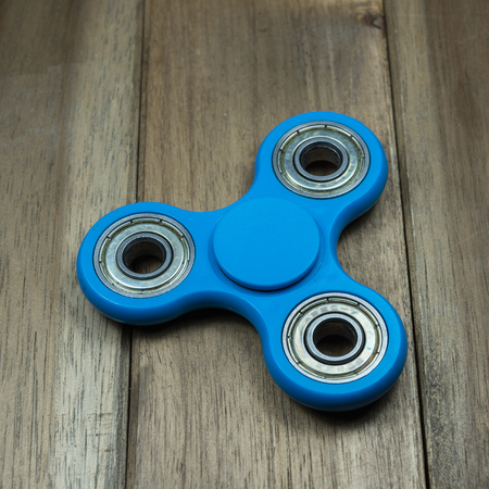 Fidget spinner on wooden tableの写真素材