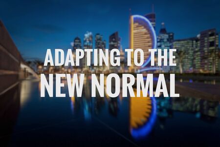 ADAPTING TO THE NEW NORMAL text on blurred background of Doha City. New normal after Covid-19 pandemic. Coronavirus outbreak concept.の写真素材