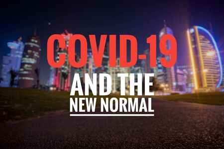 COVID-19 AND THE NEW NORMAL text on blurred background of Doha City. New normal after Covid-19 pandemic. Coronavirus outbreak concept.の写真素材