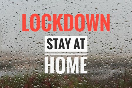 LOCKDOWN STAY AT HOME text on rainy water on glass background. Coronavirus outbreak concept.の写真素材