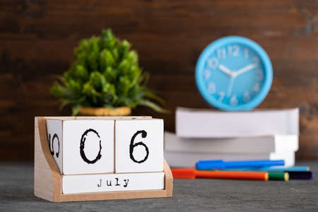 July 06th. July 06 wooden cube calendar with blur objects on background.の写真素材