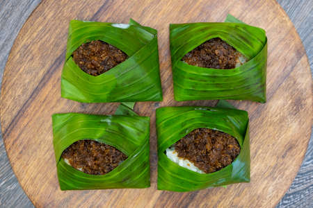 Kuih Pulut inti, traditional Malaysian dessert. Savory glutinous rice with sweetened grated coconut wrapped in banana leafの写真素材