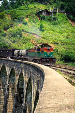 Green and red train on the famous nine arches Bridge in highlands near Ella, Sri Lanka. Jungle and tea plantation all around.のeditorial素材