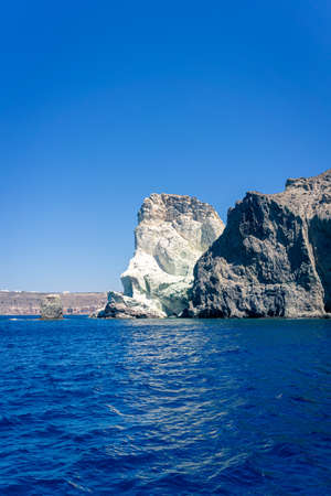 Face shaped rock on the blue sea against a blue sky. at Akrotiri, santorini, cyclades, greeceの写真素材