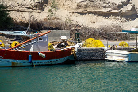 Colorful greek fishing boat and nets in a pier on Santorini, Greece.の写真素材