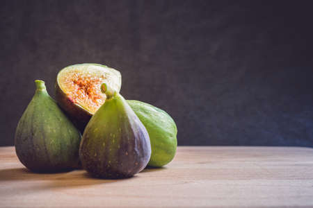 Fresh figs on a wooden table with black background. Free space for text. close-up shotの写真素材