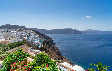 Beautiful view of Oia, the famous town with its typical white houses on a sunny day. Santorini island, Cyclades, Greece, Europe. Panoramic formatの写真素材