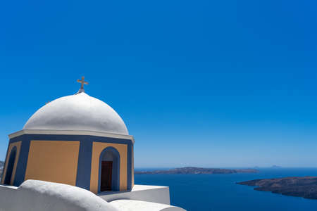 Ocher and blue dome of an orthodox church in Thira, Santorini island, Greece.の写真素材