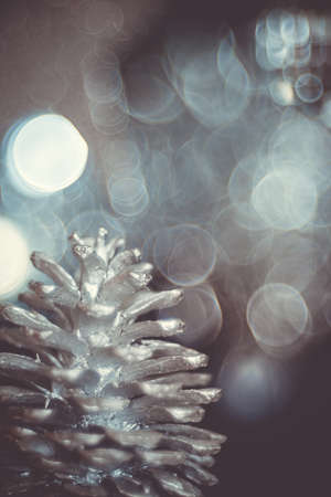 christmas decoration. close-up of a painted silver cone pine on a christmas tree. a red ball is on...