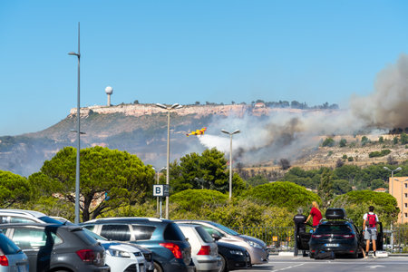 fire starts on the hills of Marseille, near Marignane airport. yellow fire-fighting plane is throwing water on it.のeditorial素材