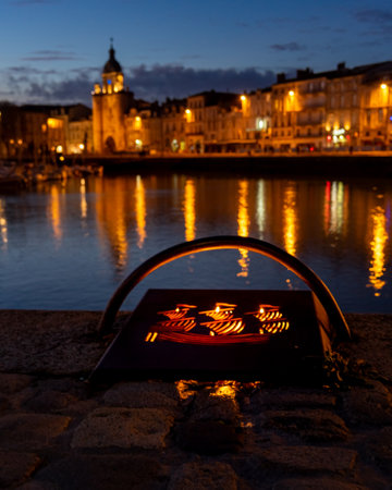 detail of an illuminated mooring in the old harbor of La Rochelle at night. blurred city lights in the backgroundのeditorial素材