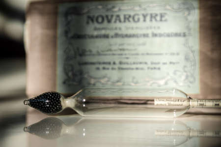 close-up of an ancient pharmaceutical ampoule in front of an old pharmaceutical box. translation: for urine. retro style. former pharmaceutical drugの写真素材