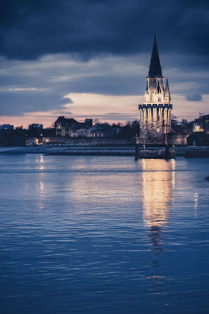Night view of the Tour de la lanterne in La Rochelle, France. beautiful reflection in the harbor waterの写真素材
