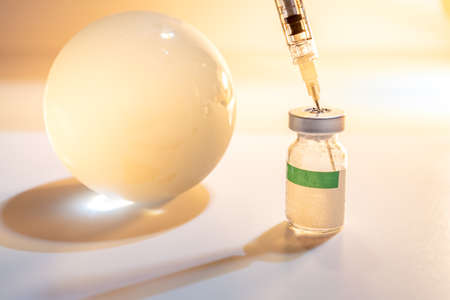Glass globe and syringe with vaccine and beaker on white background. Global health care concept