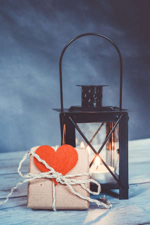 handmade gift with a red heart attached. an illuminated lantern in the background. eco friendly conceptの写真素材