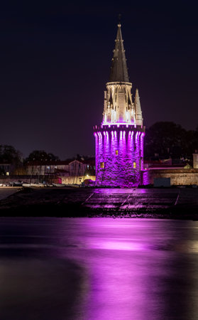 La Rochelle old harbor with its famous la lanterne tower. Night shot with pink lights for pink october.のeditorial素材