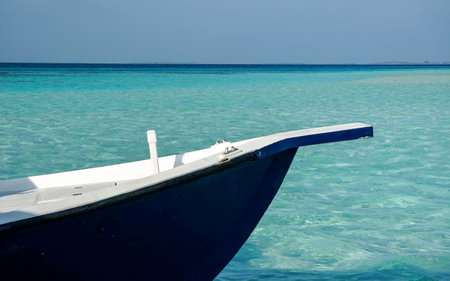 Bow of a blue and white wooden boat on turquoise water sea.の写真素材