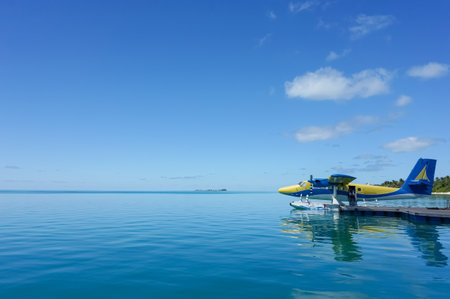 Blue and yellow seaplane on the turquoise maldivian lagoon. nature travel concept