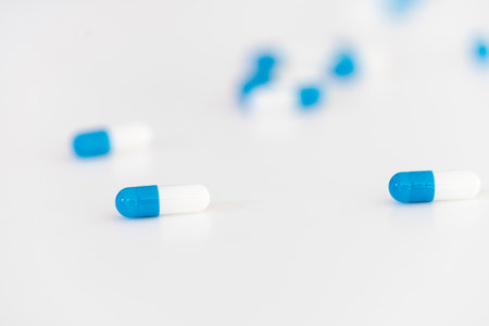 white and blue pharmaceutical medicine capsules on a white background.の写真素材