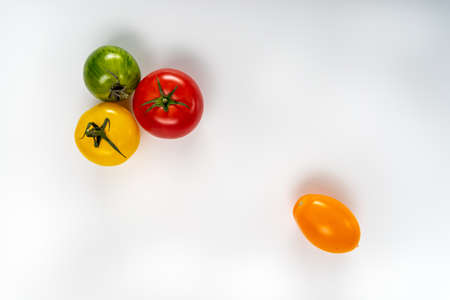 various colorful tomatoes isolated on white background. Healthy food and vegan raw eating concept, creative flat lay. copy space for textの写真素材