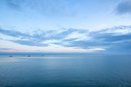 Cloudy blue minimalistic seascape. Deserted space with horizon line.の写真素材