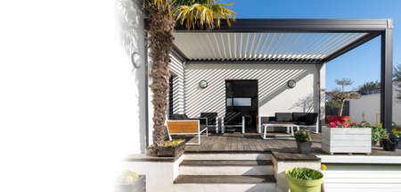 Trendy outdoor patio pergola shade structure, awning and patio roof, garden lounge and chairs. copy space for textの写真素材