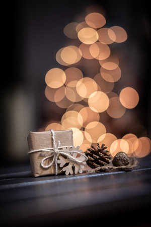 Defocused Image Of Illuminated Christmas Tree Against Black Background. sustainable gift on the...