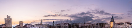 La rochelle harbor at sunset. Panorama skyline. the famous towers of La Rochelle are illuminated with christmas light. banner with copy spaceの写真素材