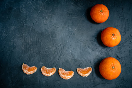 Tangerines on a black background. Tangerine slices.の写真素材