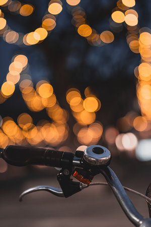 Close up Old metal bell on the handlebar of an old Bicycle outside on the street background. amazing city light in the backgroundの写真素材