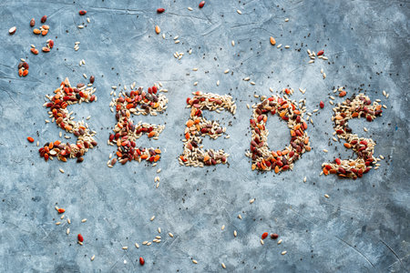 english word SEEDS is laid out on a gray background of dried seeds. View from aboveの写真素材