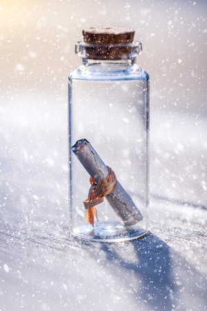 close-up of a glass vial containing a rolled-up message. scene taking place in the snowの写真素材