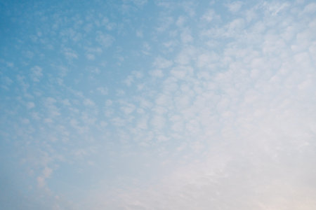 Warm-toned sky during golden hour with thin, wispy clouds. A soft and tranquil natural background ideal for serene or romantic visuals.の写真素材