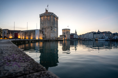 blue hour view of Port of La Rochelle guarded by tour de la chaine and tour Saint Nicholas, Franceの写真素材