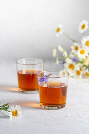 Two glasses of summer herbal tea, flowers: chamomile and cornflower.の写真素材