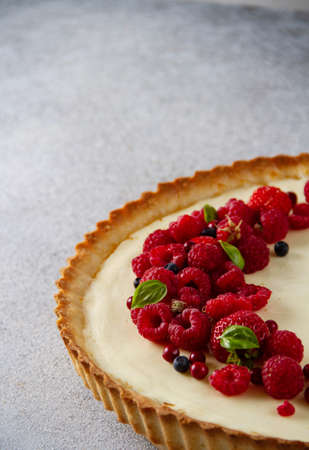 Sand tart with red berries on a gray background, close-up, part of a pieの写真素材