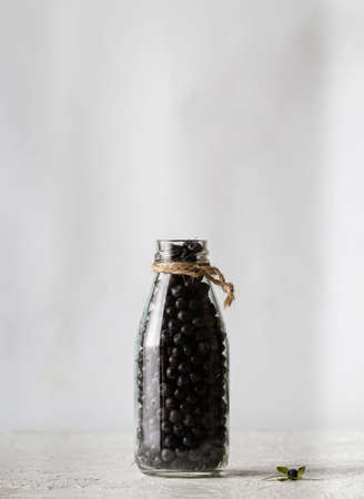 Blueberries in a glass transparent bottle on a white backgroundの写真素材
