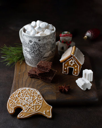 Sweets: gingerbread house, hot chocolate, chocolate, marshmallows, cookies on a wooden board, on a...