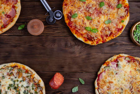 Pizza with different toppings around the edges on a wooden board made of boards, free space in the...
