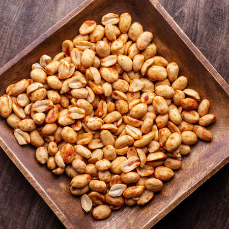 peanuts with spices and salt in a wooden plate, top view, close-up, squareの写真素材