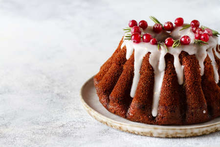 Chocolate cake with cranberries and rosemary close-up on a white plate, copy spaceの写真素材