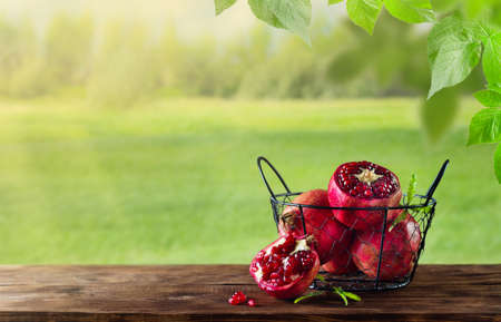 Pomegranates on a wooden table in nature, copy space, backgroundの写真素材