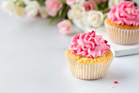 Cupcakes with pink cream with hearts and flowers, copy spaceの写真素材