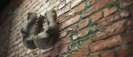 Old boxing gloves hang on nail on brick wall with copy space for text. High resolution 3d renderの写真素材