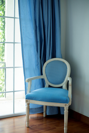 Blue fabric chair near window.の写真素材