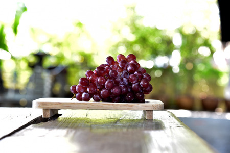 Grapes on Japanese wood tray from side view on bokeh backgroundの写真素材