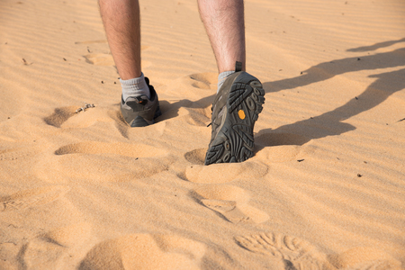 Close up shoes's man walking on sand dune.の写真素材
