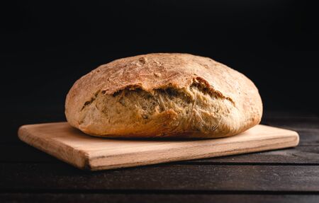 Illuminated handmade bread  on wooden and  black background.  Close up photo of Homemade bread.の写真素材