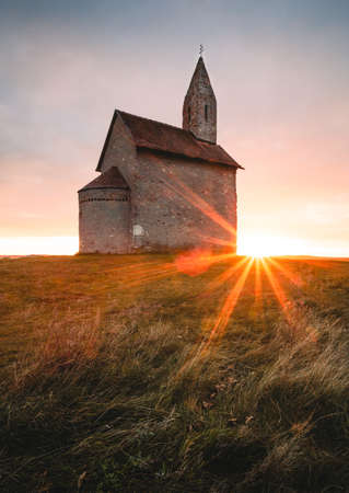 Vertical photo of old Roman Catholic Church of St. Michael the Archangel at Sunset - Drazovce, Slovakia.の写真素材